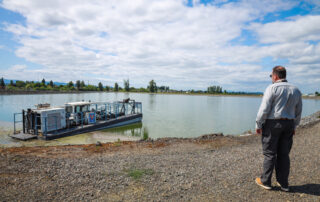 a man standing by lagoons looking at dredge