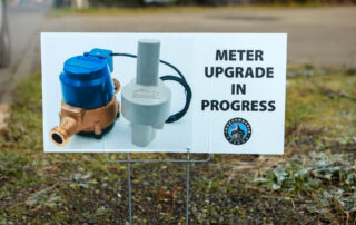 a lawn sign saying, "Meter Upgrade in Progress" with an image of a water meter on it and the city of Independence logo on it behind a white background
