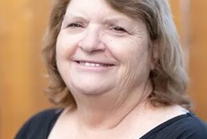 A headshot of Marilyn Morton, smiling and wearing a black shirt.