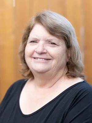 A headshot of Marilyn Morton, smiling and wearing a black shirt.