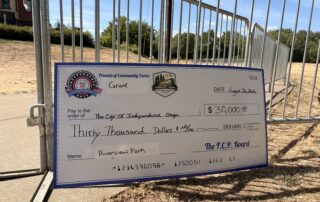 a large check displaying a $30,000 grant for community parks
