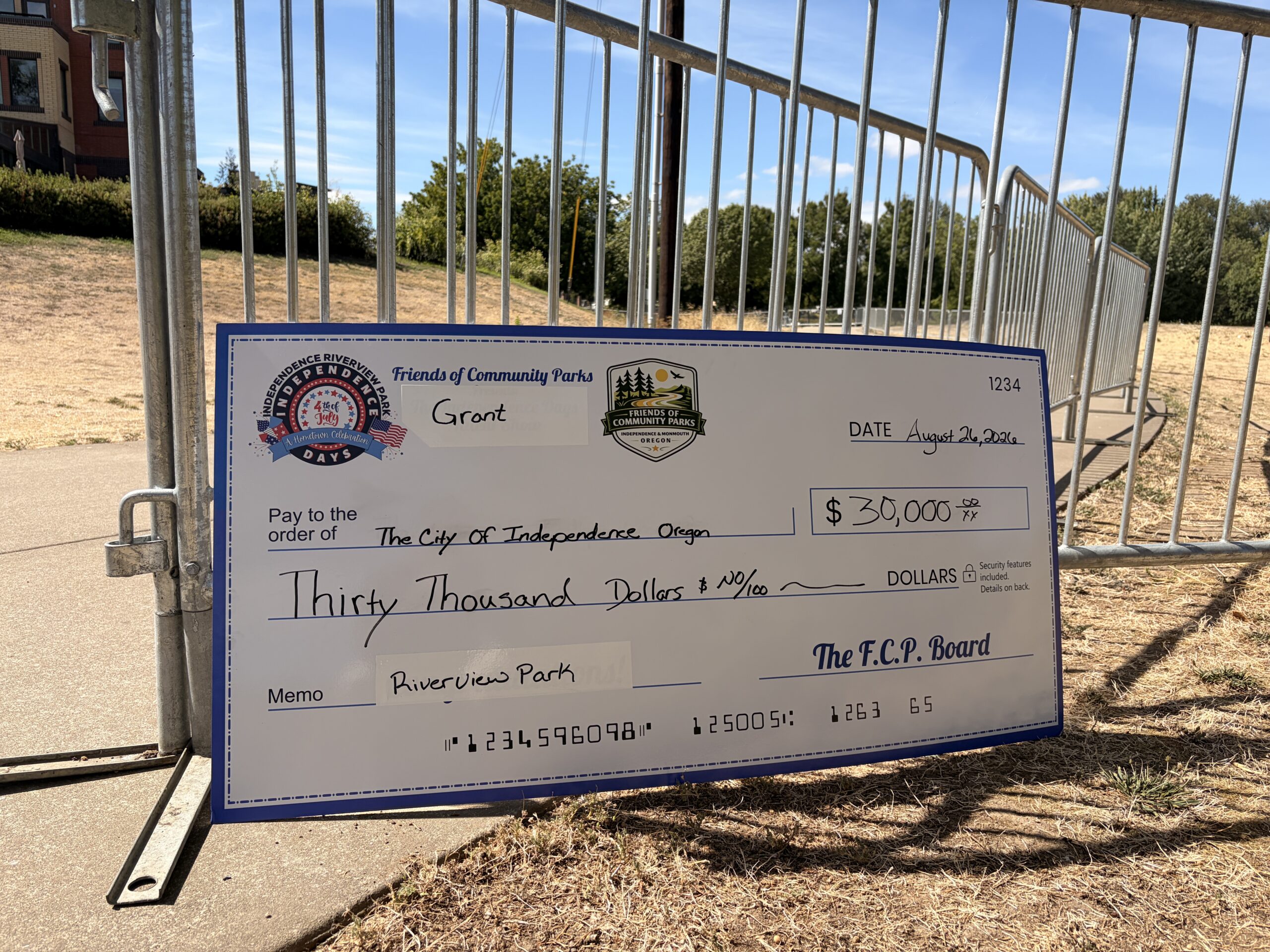 a large check displaying a $30,000 grant for community parks