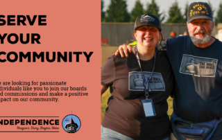 “Serve Your Community” poster invites residents to join boards and commissions; two smiling volunteers pose beside the Independence logo.